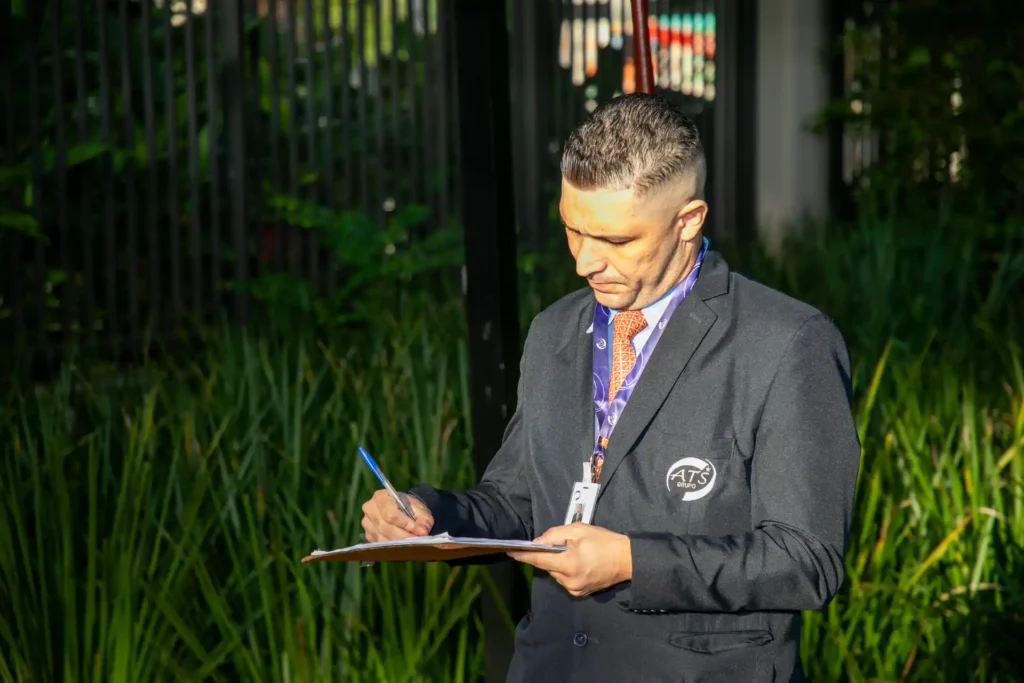 Foto de um profissional de terceirização de portaria do Grupo ATS durante o controle de acesso de visitantes, mostrando o comprometimento com a segurança e a organização da operação.