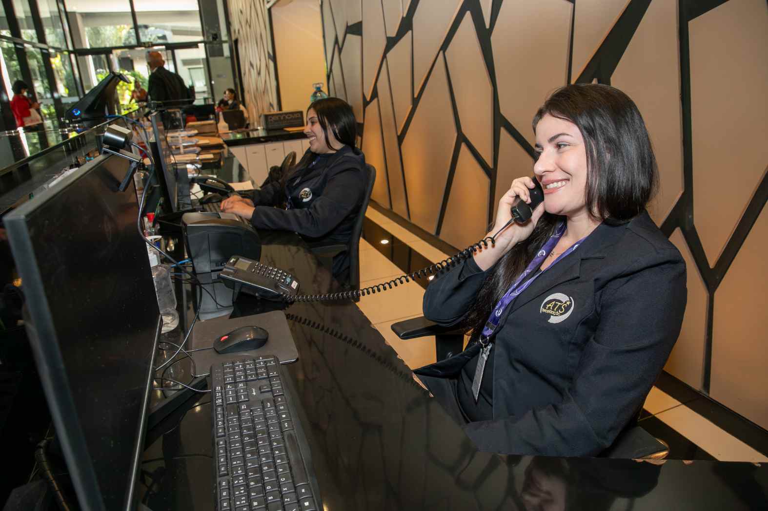Foto de profissionais do Grupo ATS durante atendimento na recepção, mostrando como a terceirização nas empresas pode auxiliar na otimização das atividades operacionais, além de oferecer uma equipe treinada e especializada para a estrutura das organizações.